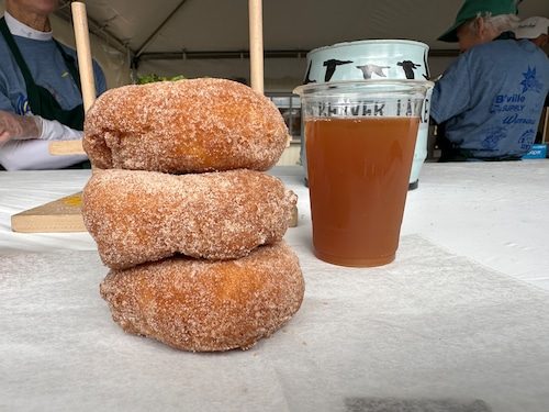Stack of cider donuts with a cup of cider